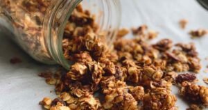Healthy homemade granola spread on baking sheet showing golden clusters and perfect texture
