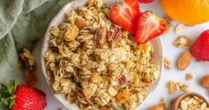 Homemade protein granola with chunky clusters in glass bowl showing texture and golden color