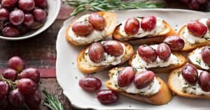 Roasted grape and goat cheese crostini arranged on serving platter