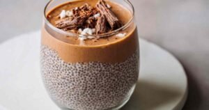 Coffee chia seed pudding in mason jar topped with coconut cream and cocoa powder