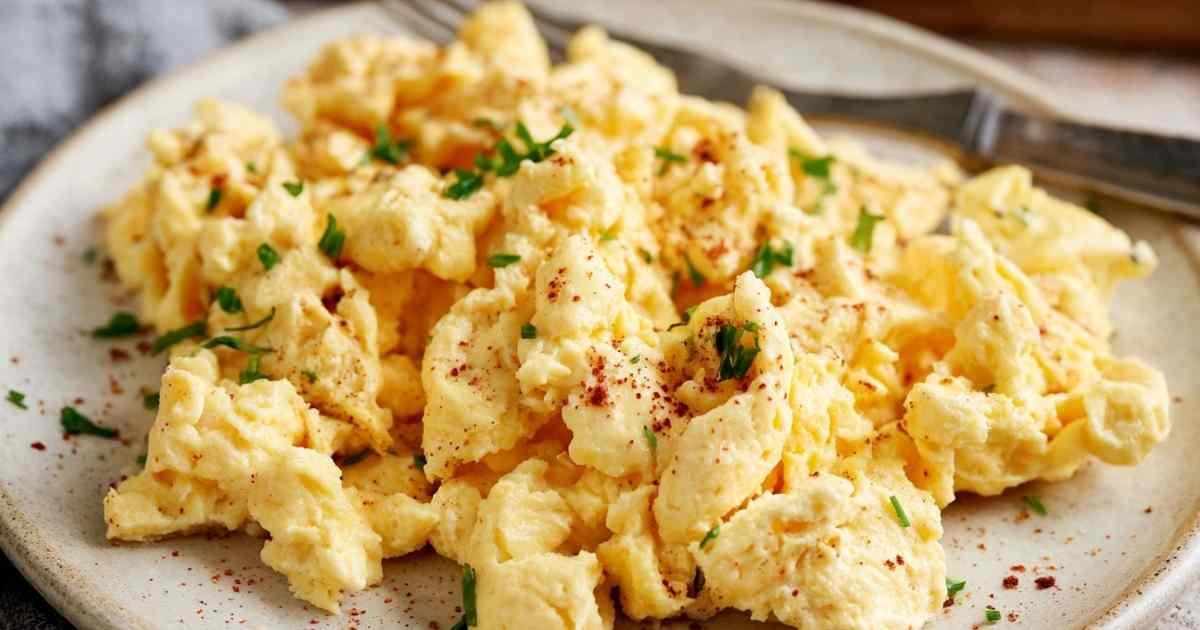 Scrambled eggs with cottage cheese cooking in pan showing creamy fluffy texture