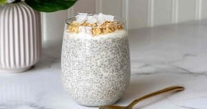 Easy coconut chia pudding served in glass jars topped with shredded coconut and Greek yogurt