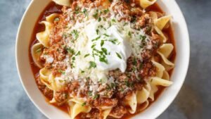 Easy Lasagna Soup in white bowl topped with ricotta and parmesan cheese