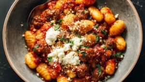 Millionaire Gnocchi in large skillet topped with herbed ricotta and golden breadcrumb crispies