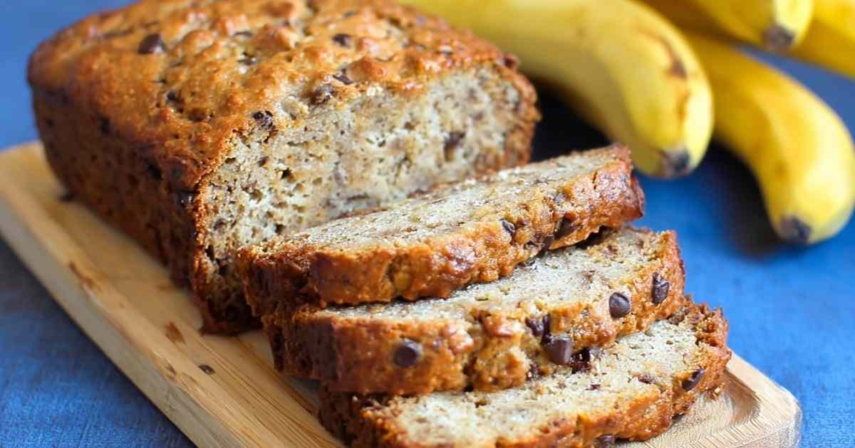Single slice of protein banana bread topped with almond butter on white plate