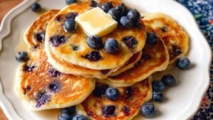Stack of fluffy vegan protein pancakes with syrup drizzled on top showing perfect texture