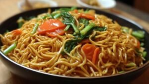 Easy Lo Mein recipe cooking in wok with colorful vegetables and noodles being stir-fried