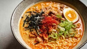 Easy Buldak Soup Ramen in bowl with tender chicken, springy noodles, scallions and sesame seeds