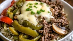Philly Cheesesteak Bowl with melted cheese, steak, and peppers over cauliflower rice