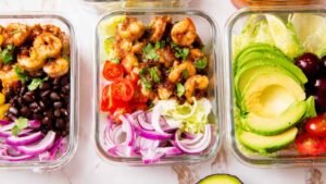 High protein shrimp taco rice bowl with seasoned shrimp, black beans, avocado, and fresh vegetables