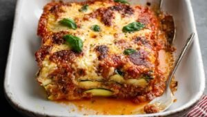 Slice of baked zucchini lasagna no noodles showing protein-packed layers with melted cheese and roasted zucchini