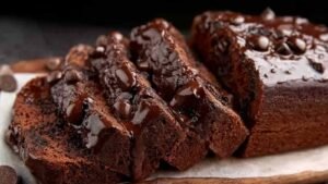 Healthy chocolate banana bread sliced on wooden cutting board showing moist texture