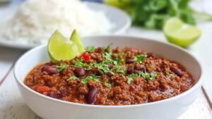 Classic Chilli Con Carne in large skillet with ground beef and kidney beans