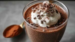 High protein chocolate chia pudding in glass jar topped with berries